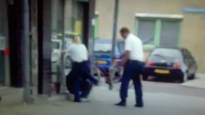 Still uit het filmpje waarop is te zien hoe een politieagente van het korps Rotterdam-Rijnmond een man meerdere keren schopt.