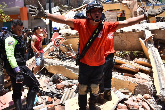 Reddingswerkers tussen het puin van een door de aardbeving verwoest huis in Machala, de hoofdstad van de Ecuadoriaanse provincie El Oro.