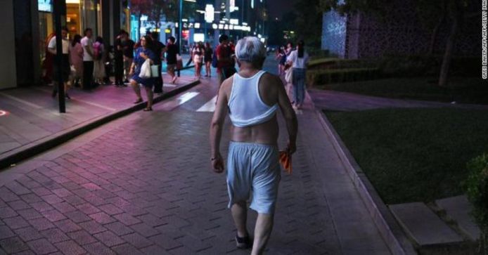 Chinese mannen rollen hun shirt op om af te koelen.