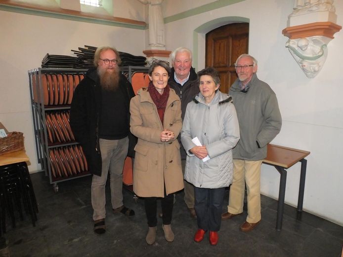 Piet Herregods (links), Sanne Vermeeren en enkele vrijwilligers van de parochie voor het rek met klapstoelen.