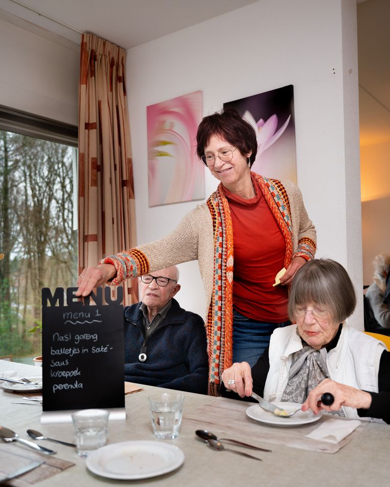 Verzorgende Anneke Sondaal (met menu), en bewoners Steef Oosterbeek en Bess Akkerman. Beeld Bram Petraeus