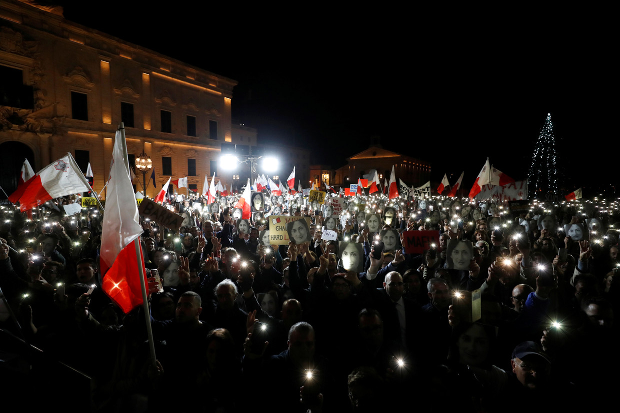Demonstranten die de foto van de vermoordde journaliste Caruana Galizia dragen in de Maltese hoofdstad Valletta.   Beeld Reuters