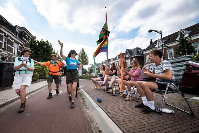 Huisgenoten moedigen wandelaars aan op de Sint Annastraat.