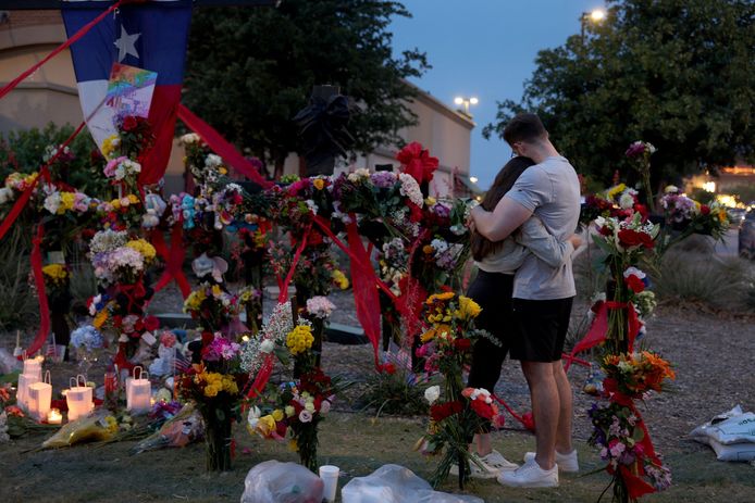 Mensen rouwen en troosten elkaar bij de memorial naast het 'Allen Premium Outlets' winkelcentrum in Texas, waar gisteren acht mensen om het leven kwamen bij een schietpartij.
