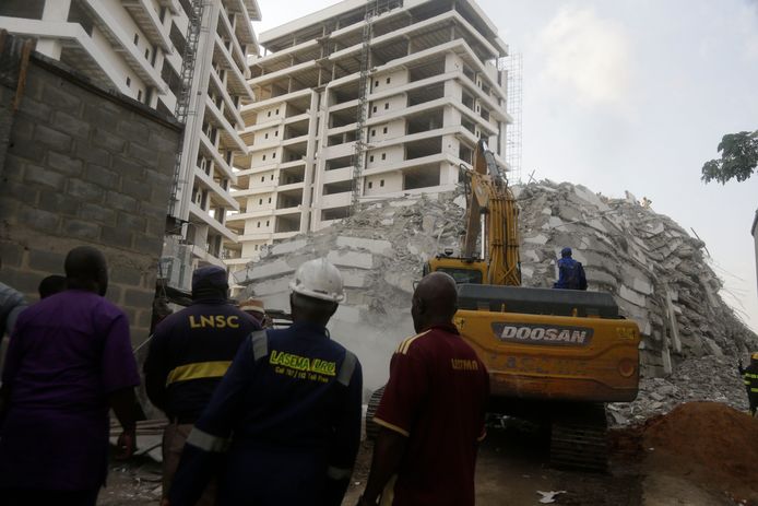 Reddingswerkers tussen het puin van het ingestorte flatgebouw in aanbouw in Lagos.