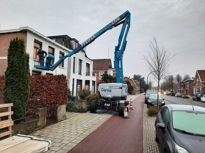 Met een hoogwerker wordt geluidsisolatie aangebracht bij woningen aan de Deldenerstraat in Hengelo.