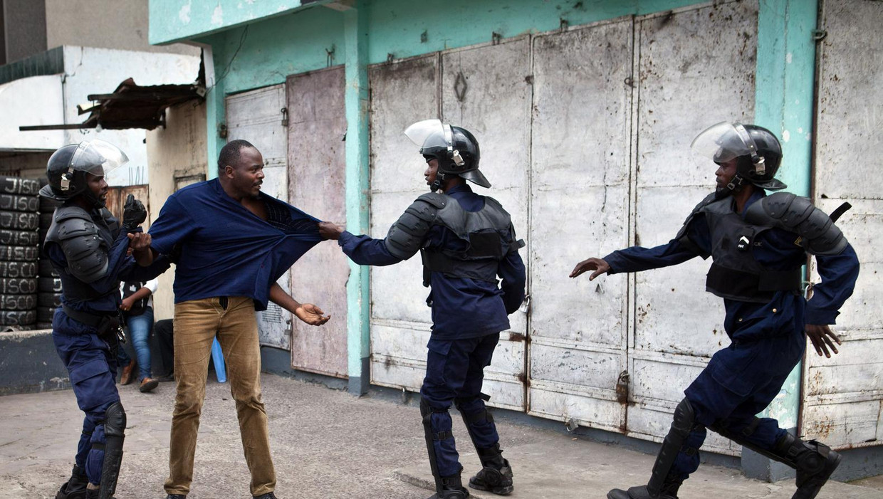 Een supporter van de Unie voor Democratie en Sociale Vooruitgang (UDPS), de partij van oppositieleider Etienne Tshisekedi, wordt aangepakt door de oproerpolitie. Beeld afp