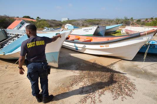 De gevonden bootjes van bootvluchtelingen  worden gedumpt op het Pindakaasterrein, een kale graslap achter de marinebasis op Aruba. Waaraan de locatie zijn naam ontleent, weet niemand meer. Het is een verzamelplek voor zo’n vijftien wrakken met namen als Crazy Frog (rare kikker) of Dios verá (God zal kijken).