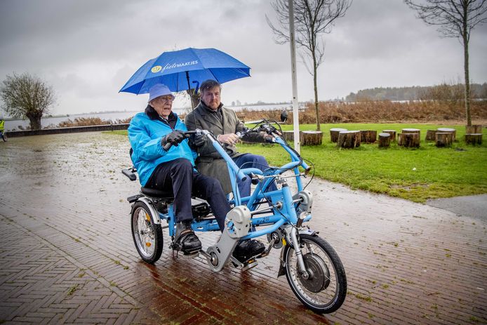 2019-11-28 14:49:53 WARMOND - Koning Willem-Alexander op de duofiets tijdens een werkbezoek aan de Stichting Fietsmaatjes.