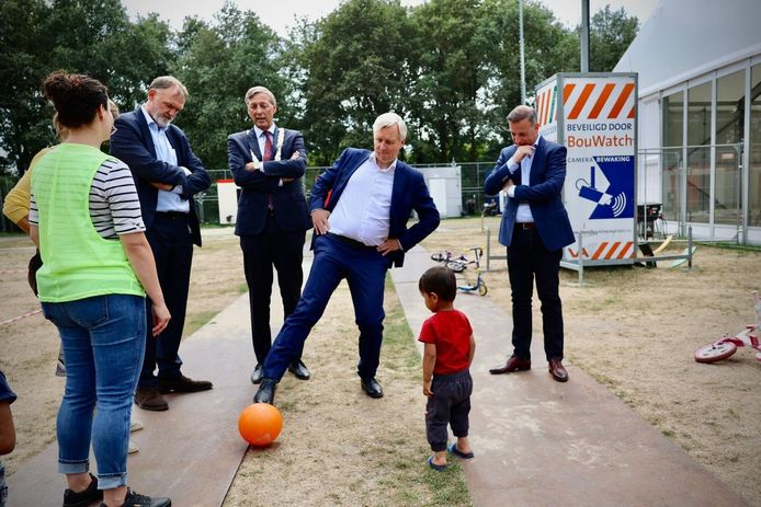 Staatssecretaris Eric van der Burg trapt een balletje met een jochie in de crisisnoodopvang voor asielzoekers in de gemeente Maashorst.