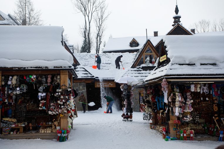 In het Poolse skioord Zakopane wordt de sneeuw van de daken geveegd. De winkels wachten vergeefs op klanten, want op last van de overheid ligt de wintersportsector stil. Beeld Piotr Malecki