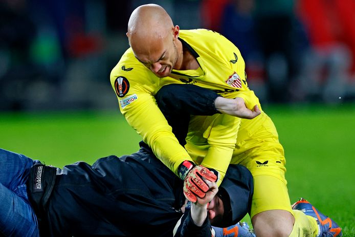 Een toeschouwers valt Marko Dmitrovic aan bij PSV-Sevilla FC.