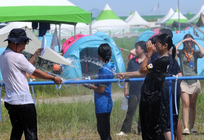 Deelnemers van het evenement proberen elkaar met water af te koelen.