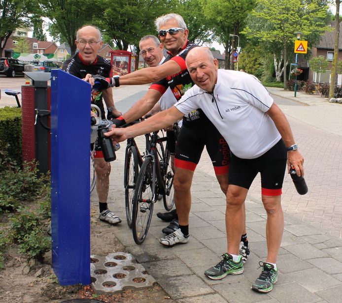 Wielrenners maken gebruik van het gratis water.
