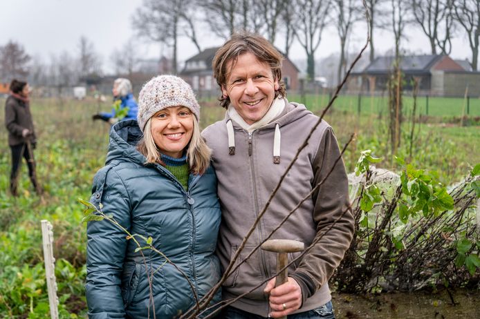 Kestrel Maher en Geert-Jan van Nistelrooij voor het veld waar vrijwilligers - in de achtergrond- weer een flinke hoeveelheid bomen voor het voedselbos aanplanten.