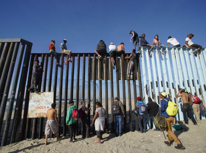 Migranten aan de grensmuur tussen Mexico en de VS in Tijuana.
