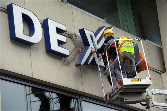 Het logo van Dexia wordt van de muur van een kantoor verwijderd in 2012. Met zijn onderzoek wil het Brusselse parket de personen identificeren die zich schuldig gemaakt hebben aan belastingontduiking of het faciliteren van deze belastingontduiking.