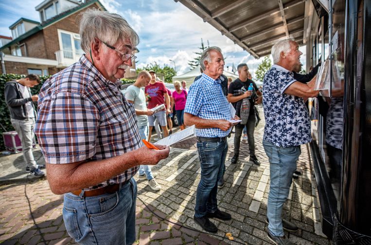 Inwoners van Hillegom wagen een gokje bij  het mobiele wedkantoor van Runnerz. Beeld Raymond Rutting / de Volkskrant