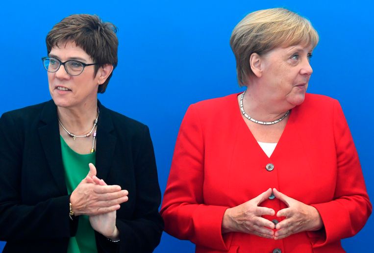 Minister Annegret Kramp-Karrenbauer (L) en Angela Merkel. Beeld AFP