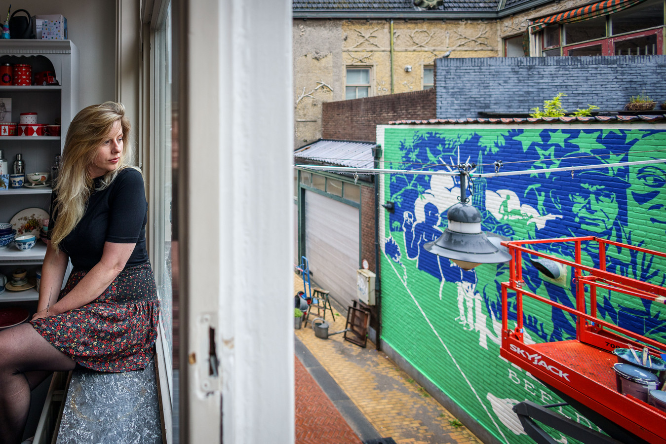 Anna-Eva Hoekstra kijkt naar de muurschildering die vorige week voor haas huis aan de Kalverstraat in Steenwijk is aangebracht.
