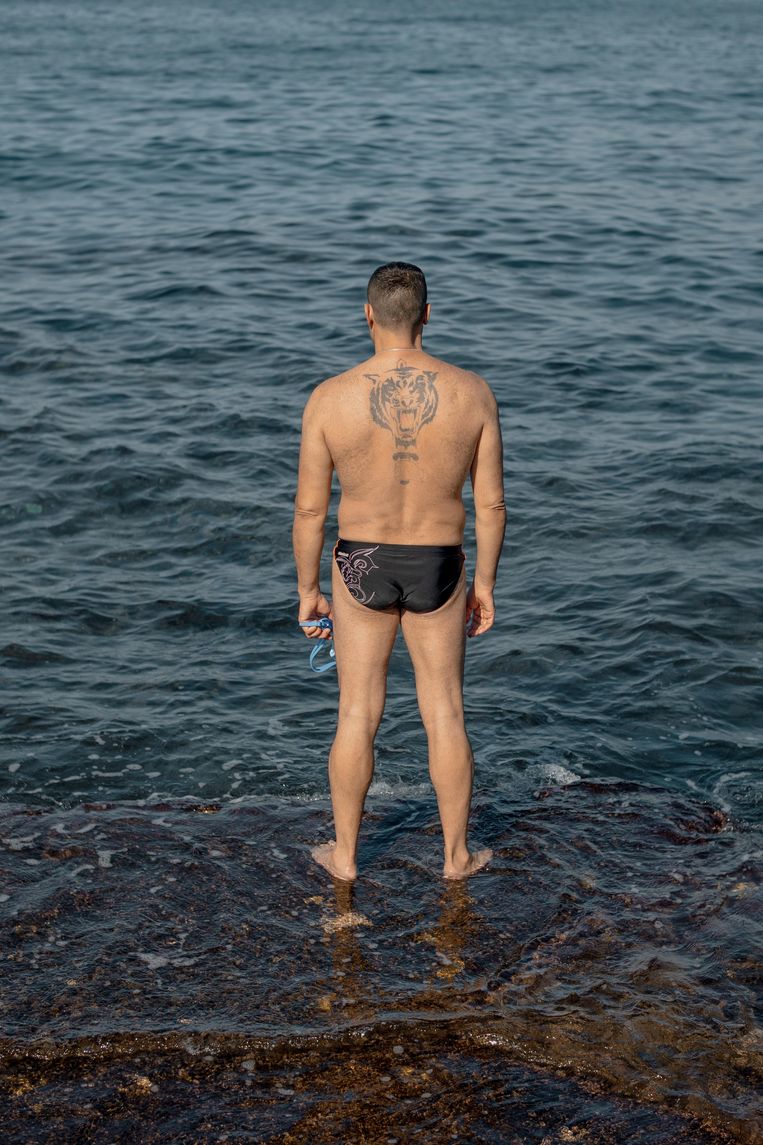 Mahmoud Hammoud staat klaar om de zee in te duiken aan de boulevard van Beiroet.  Beeld Aline Deschamps