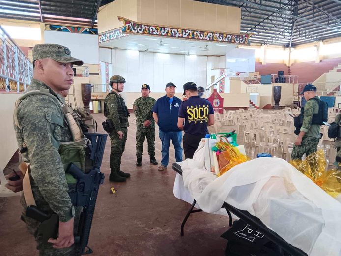 Gouverneur Mamintal Adiong Jr. van de provincie Lanao Del Sur bekijkt met politieagenten de plaats waar de explosie plaats heeft gevonden.