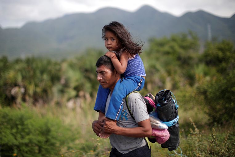Een man uit Guatemala loopt met zijn dochter via Mexico naar de VS. Zij zijn slechts twee van de duizenden migranten. Beeld REUTERS
