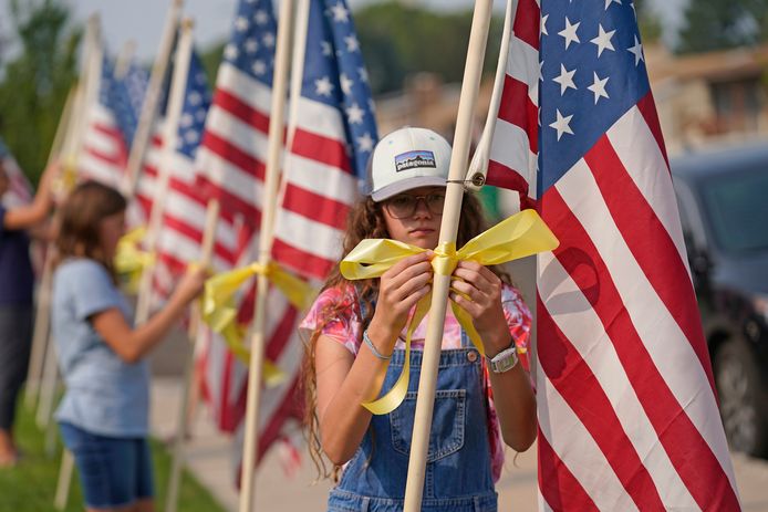 Buurtbewoners van het ouderlijke huis van Taylor Hoover in Sandy (Utah) plaatsen Amerikaanse vlaggen.