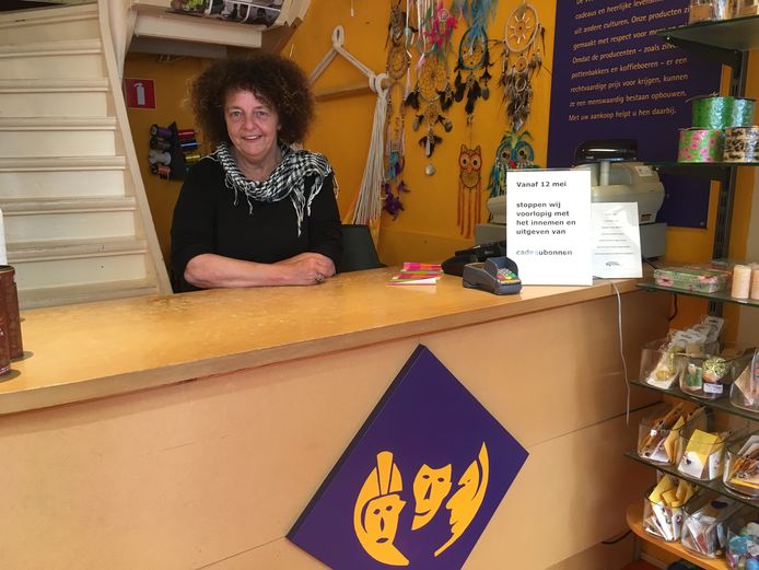 Heleen Schreurs achter de toonbank van haar Wereldwinkel in Deventer. Een bordje maakt duidelijk dat cadeaubonnen er niet meer worden geaccepteerd. ,,Ze maken er een zootje van."
