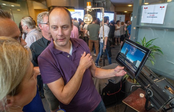 Jeroen Haas, één van de bezorgde omwonenden van Heesch West, toont tijdens de inloopbijeenkomst een visualisatie.