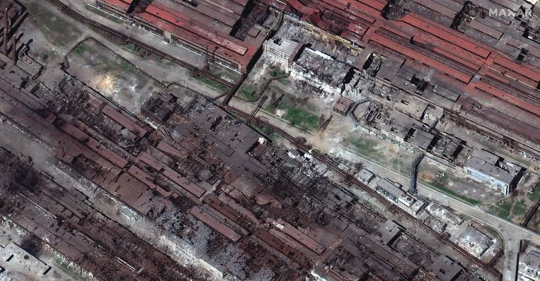 Satellietfoto van de Azovstal-fabriek in Marioepol, genomen op 30 april. Het terrein is zwart geblakerd van de bombardementen door de Russen. Sindsdien regende het nog veel meer bommen en raketten op het terrein. 
 Beeld AFP