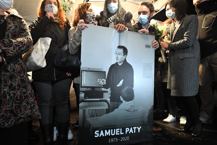 Familieleden en collega's met een foto van Samuel Paty tijdens de 'Witte Mars' ter nagedachtenis aan hem in Conflans-Sainte-Honorine ten noordwesten van Parijs.