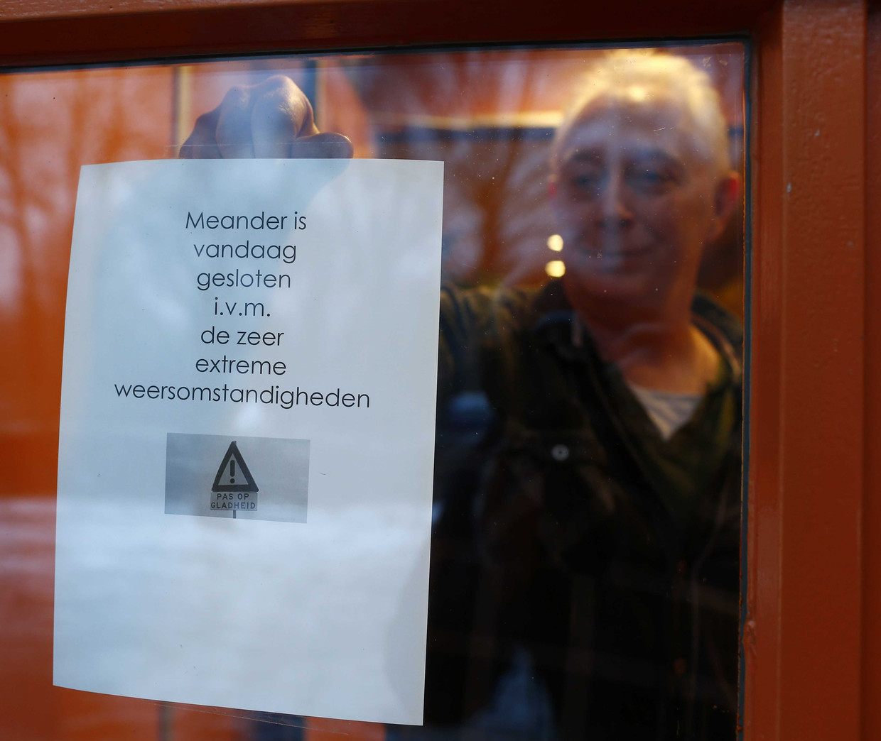 Een mededeling op een raam van een school in Assen die is gesloten vanwege het extreme weer. Beeld ANP