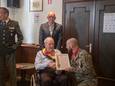 Victor Hannes, met achter hem zijn zoon Fons, krijgt het diploma uitgereikt dat gepaard gaat met de titel van ere-korporaal.