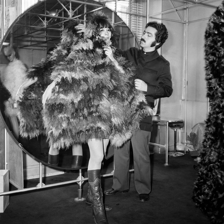 (FILES) In this file photo taken on March 20, 1968, Spanish designer Paco Rabanne helps a model as she wears a scarf of Mongoly goat, in his shop in Paris. - Spanish fashion designer Paco Rabanne, known for his eccentric clothing designs and for founding one of the world's best-known fragrance brands, died on Friday at the age of 88. 
Rabanne's death was confirmed to AFP by the parent company of his brand, who said he had 