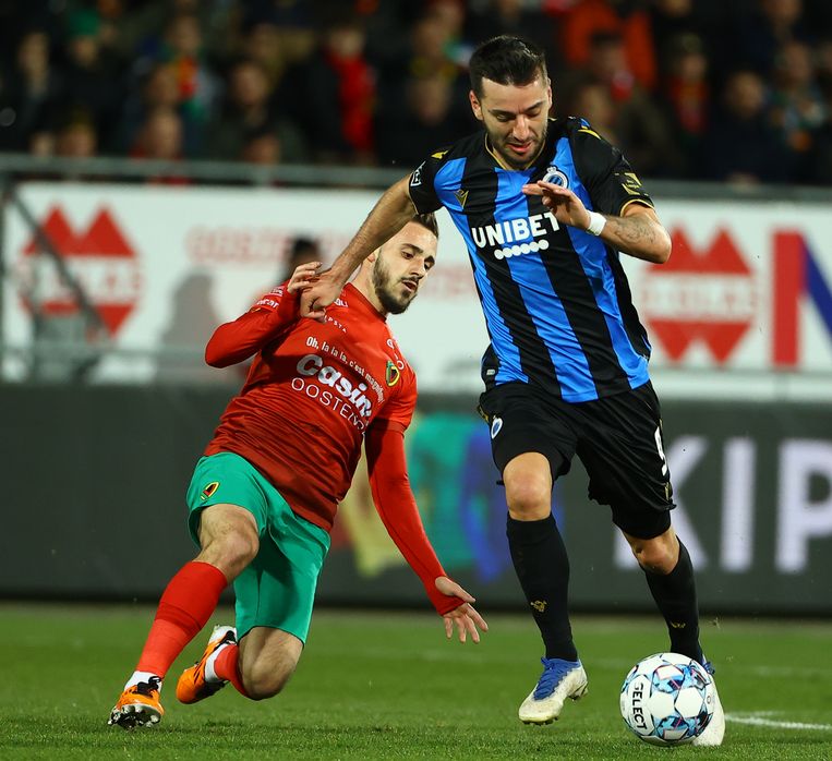 KV Oostende-speler Alessandro Albanese zet een sliding in om Sargis Adamyan van Club de bal te ontfutselen. Beeld BELGA