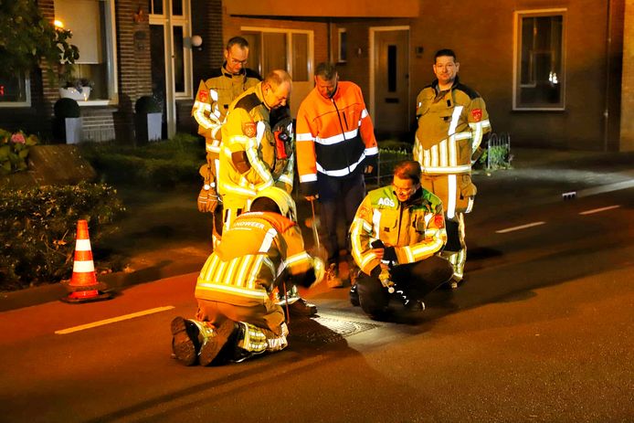 De brandweer meet met een sensor waarden uit de put.