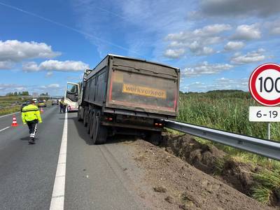 Vrachtwagen staat met vier wielen vast in berm langs A59 bij Terheijden, rijstrook dicht en veel vertraging