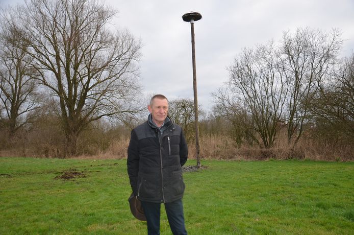 Initiatiefnemer Johan Allard uit Okegem aan de ooievaarspaal werd geplaatst op het domein van kaatsvereniging de Amusanten aan de Fonteinstraat.