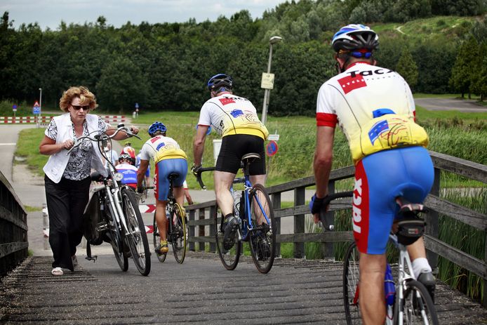 Op een bruggetje over de Rotte tussen Ommoord en Bergschenhoek passeren wielrenners en recreanten elkaar