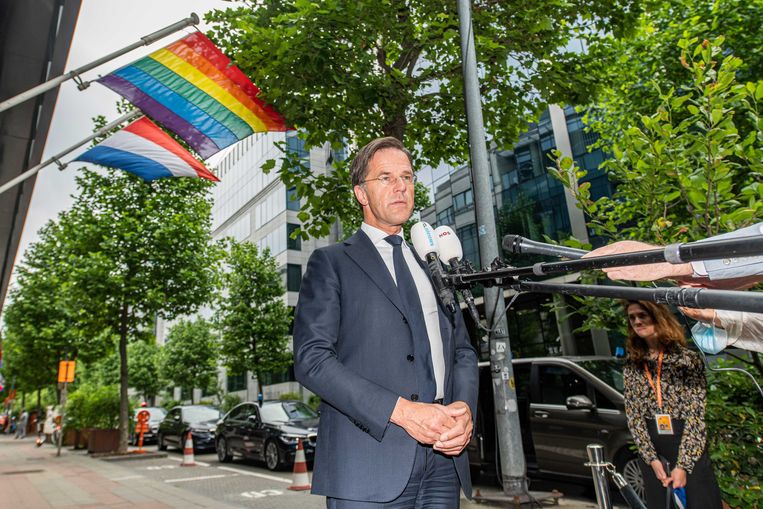 De Nederlandse premier Mark Rutte staat de pers te woord bij het gebouw van de Nederlandse vertegenwoordiging in de EU voor de eerste dag van de Europese top. Achter hem heel bewust een wapperende regenbloogvlag. Beeld ANP