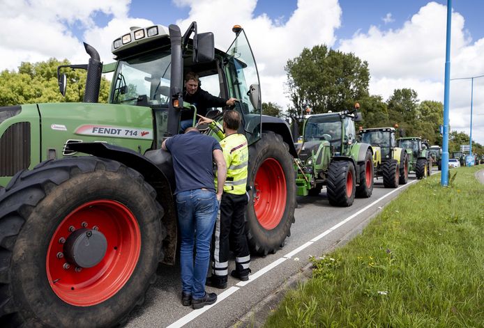 Thijs Wieggers (in de trekker) en Rutger van Lier (op de rug gezien) in gesprek met een agent tijden het boerenprotest vrijdag.
