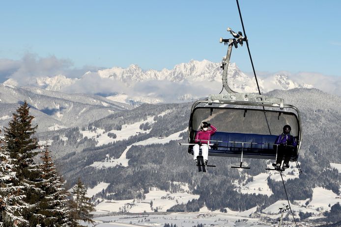 Wintersporters houden anderhalve meter afstand in een skilift in Flachau, Oostenrijk.