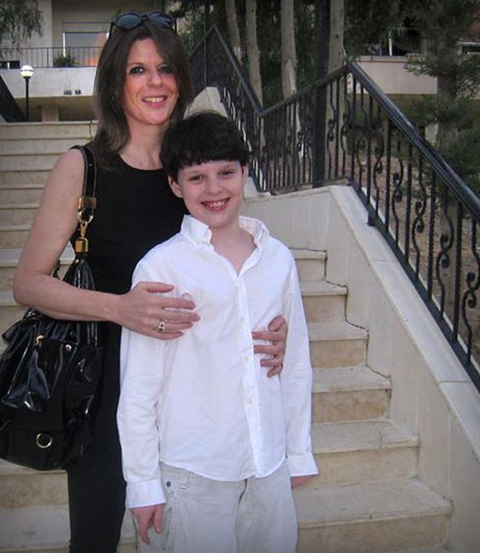 Nicole Wouters en haar jongste zoon Sam voor de deur van hun flat in een buitenwijk van Damascus