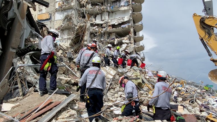 Reddingsploegen werken op de instabiele bergen cement en staal in de hoop overlevenden te vinden.  Beeld via REUTERS