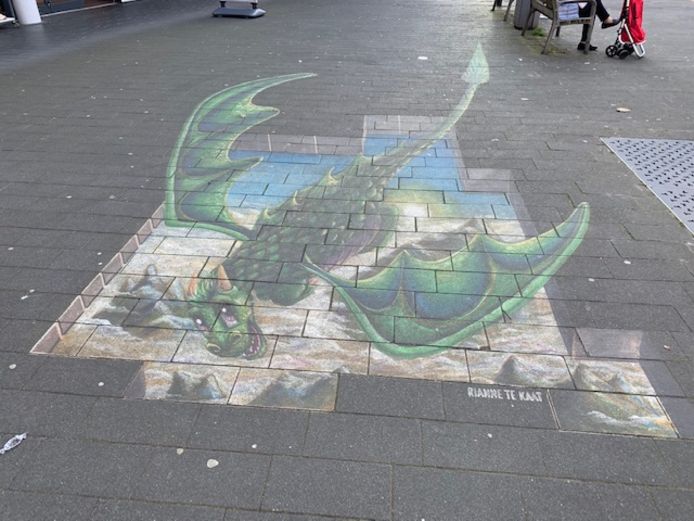 De grondschildering van de draak die Te Kaat vorig jaar heeft gemaakt voor het winkelcentrum. Die is al een beetje aan het vervagen.