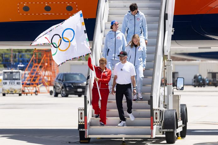 Los Angeles mayor Karen Bass (L bottom) waves the Olympic flag alongside LA28 chairman Casey Wasserman (R bottom), US springboard diver Delaney Schnell (R center), US skateboarder Tate Carew (2nd L),  and US volleyball player Micah Ma?a (back) after their plane landed during an event celebrating the arrival of the Olympic flag at Los Angeles International Airport (LAX) in Los Angeles, on August 12, 2024. Los Angeles will host the 2028 Summer Olympic Games. (Photo by Etienne LAURENT / AFP)