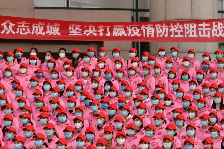 Medisch personeel verzamelt zich voor vertrek naar Shanghai, waar miljoenen mensen in lockdown zitten. Op een banier staat ‘Verenig u, en win vastbesloten de strijd om preventie en beheersing van de epidemie’.  Beeld AP