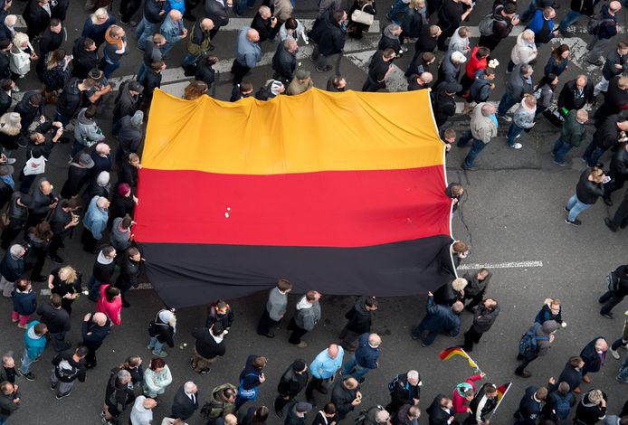 Rechtse betogers van de extreemrechtse partij AfD, de antimoslimbeweging Pegida en Pro Chemnitz dragen de Duitse vlag door de straten.