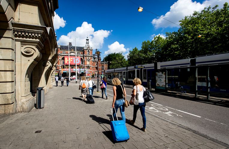 Toeristen met rolkoffers op het Leidseplein in Amsterdam. Beeld ANP